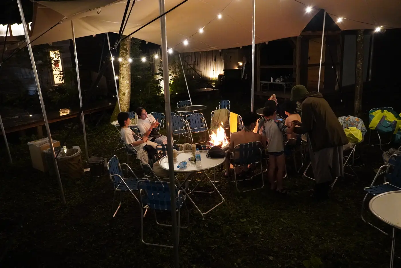 夜のテントの下でくつろぐ来場者