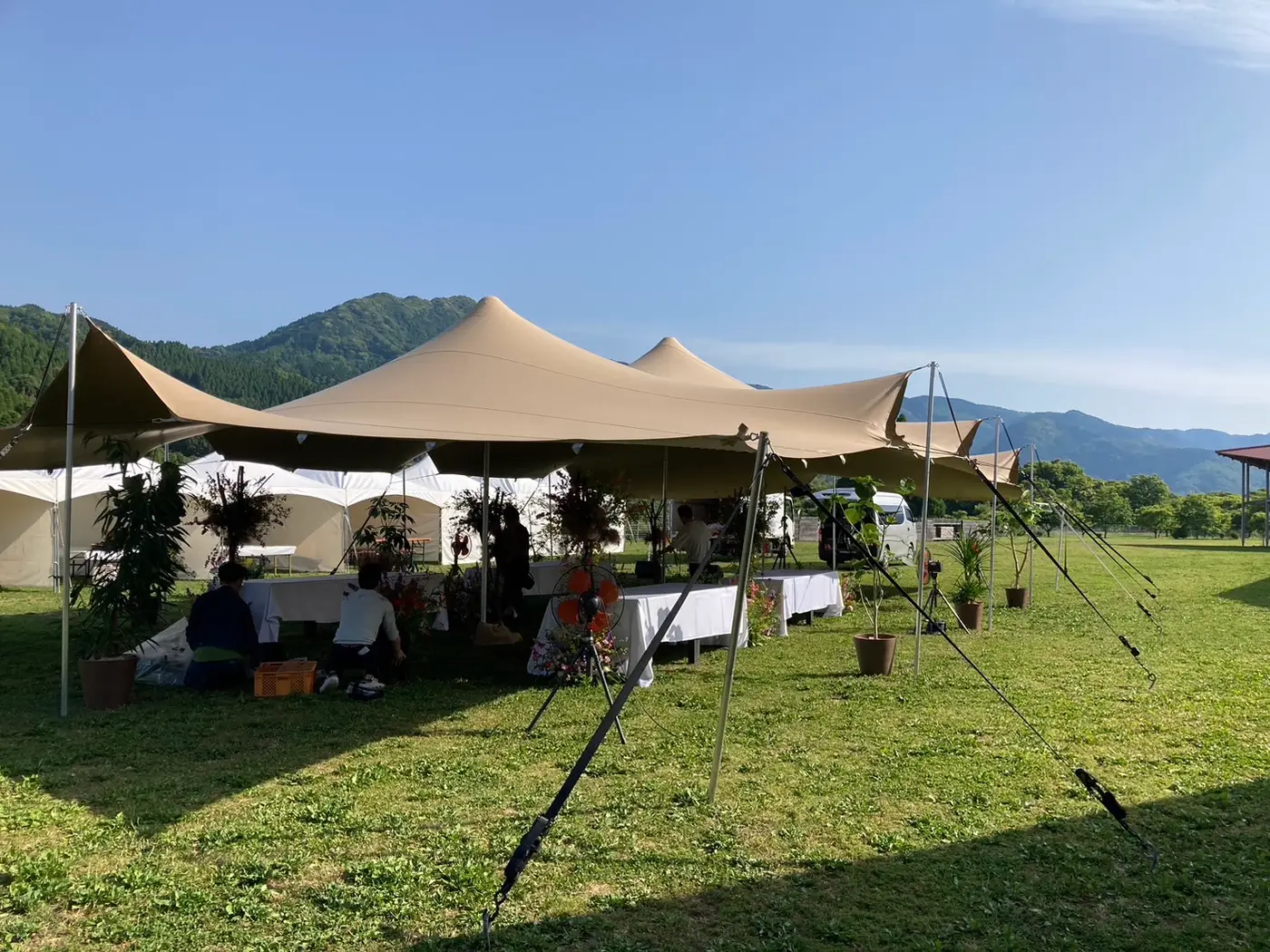 山を背にした芝生の会場のストレッチテント